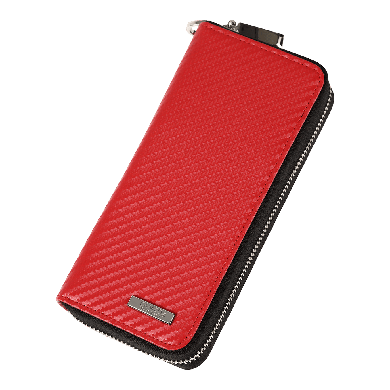 Das Bild zeigt ein rotes Etui mit einer strukturierten Oberfläche und einem Reißverschluss. An der unteren Ecke befindet sich ein kleines Metallschild mit einer Gravur.
