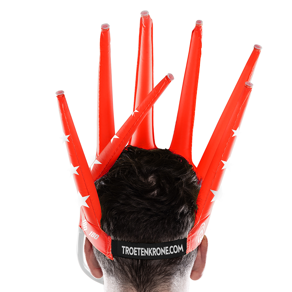 9026-McDart-180-er-Tr-tenkrone-3QhBeOlKOPs3Ze Eine Person trägt eine auffällige, rote, aufblasbare Krone mit mehreren Spitzen auf dem Kopf. Auf der Rückseite steht der Schriftzug "TROETENKRONE.COM".
