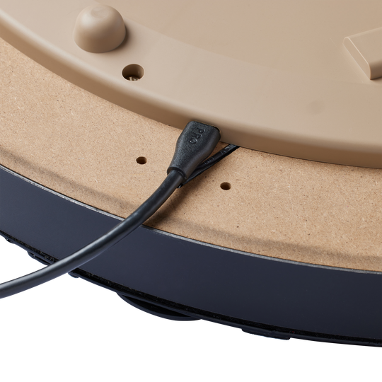 Das Bild zeigt die Rückseite des Unicorn Eclipse Smartboard Steeldartboards mit einem angeschlossenen Kabel. Das Kabel ist in einen Anschluss an der braunen Rückseite des Dartboards eingesteckt.