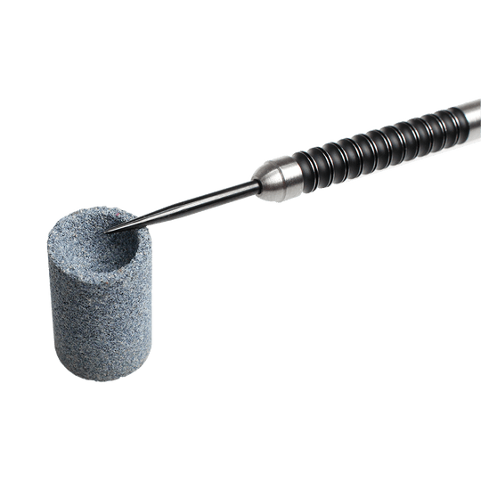 667_Winmau_Keyring_Dart_Sharpener_Schleifstein_2 Das Bild zeigt einen Winmau Keyring Dart Sharpener Schleifstein. Eine Dartspitze wird in den runden Schleifstein eingeführt, um sie zu schärfen.