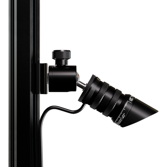 Target MOD Laser Oche Das Bild zeigt das Produkt "Target MOD Laser Oche", das an einer vertikalen Stange befestigt ist. Es handelt sich um ein schwarzes, zylindrisches Gerät mit einem Kabelanschluss und feinen Details.