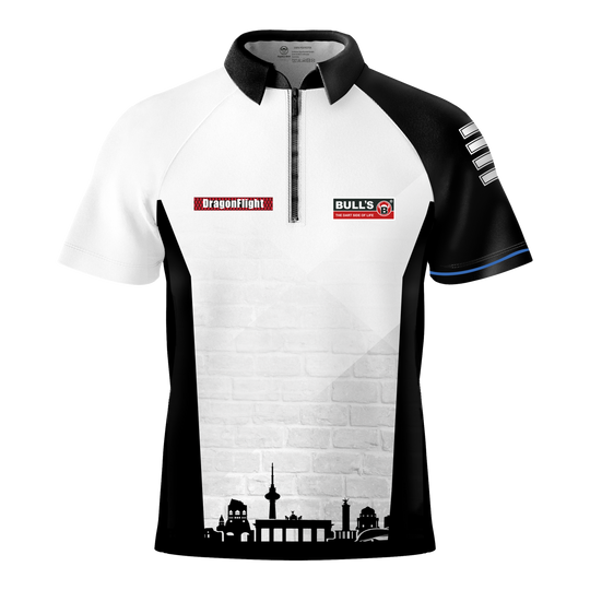 Bulls Martin Schindler The Wall dart shirt Das Bild zeigt das Bulls Martin Schindler The Wall Dartshirt mit einem schwarz-weißen Design und kurzen Ärmeln. Auf der Vorderseite befinden sich Logos und eine stilisierte Stadtsilhouette am unteren Rand.