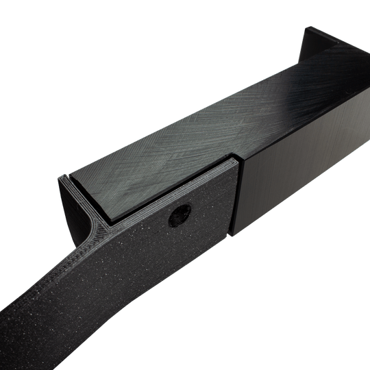 MC_Scolia_Abstandshalter_zur_Wandmontage_4 Das Bild zeigt einen schwarzen Abstandshalter zur Wandmontage, der für das Scolia Home 1 System verwendet wird. Das Produkt besteht aus stabilem Material und hat eine rechteckige Form mit einer Befestigungsöffnung.