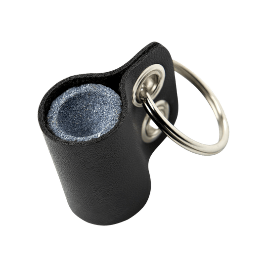 667_Winmau_Keyring_Dart_Sharpener_Schleifstein_1 Das Bild zeigt einen Winmau Schlüsselanhänger Dart- Schärfer Schleifstein. Er besteht aus einem kleinen Schleifstein in einer schwarzen Hülle mit einem Metallring zum Befestigen am Schlüsselbund.