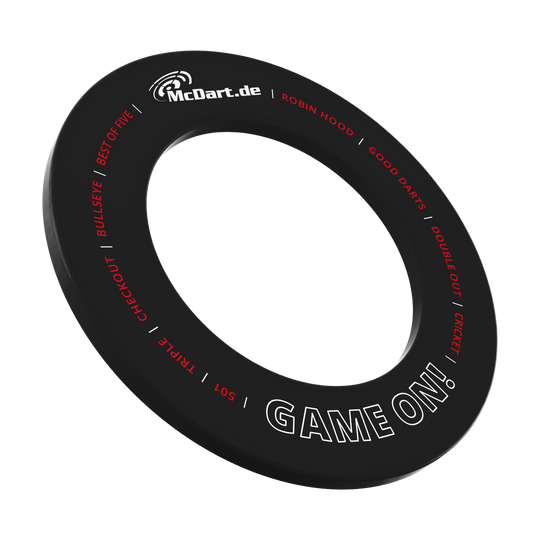 McDart Game On Dartboard Surround Das Bild zeigt einen schwarzen Dartboard-Surround-Ring mit der Aufschrift "McDart.de" und "GAME ON!". Um den Ring sind weitere Begriffe rund um das Dartspiel in Rot und Weiß geschrieben.