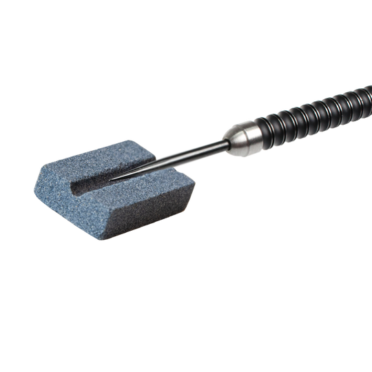 616_QD8200690_XQMax_Steeldart_Schleifstein_2 Das Bild zeigt einen XQMax Steeldart Schleifstein mit einem Dartpfeil darauf. Der Schleifstein wird verwendet, um die Spitze des Dartpfeils zu schärfen.