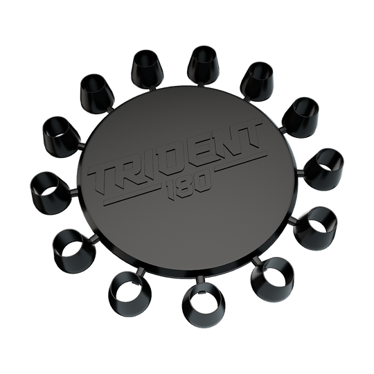 641_Winmau_Trident_180_Kappen_1 Das Bild zeigt das Produkt "Winmau Trident 180 Kappen". Es handelt sich um eine runde, schwarze Scheibe mit mehreren kleinen Aufsteckkappen rundherum und dem Schriftzug "TRIDENT 180" in der Mitte.