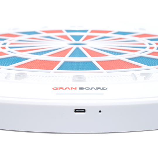 g01440_GranBoard_132_Elektronisches_Dartboard_3 Das Bild zeigt das elektronische Dartboard „GranBoard 132“ mit einem modernen, farbigen Design. Im Vordergrund ist der USB-Anschluss des Geräts gut sichtbar.