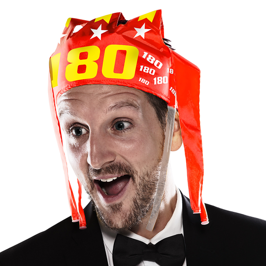 9026-McDart-180-er-Tr-tenkrone-2HGdV9DCXoxGIZ Ein Mann trägt eine auffällige, rote Partykrone mit der Aufschrift "180" und weißen Sternen. Er sieht überrascht und fröhlich aus.