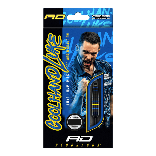 Auf der Verpackung sind die "Red Dragon Luke Humphries World Champion Brass Steeldarts" abgebildet. Im Hintergrund ist ein jubelnder Spieler zu sehen, daneben ist ein Dartpfeil durch ein Sichtfenster sichtbar.