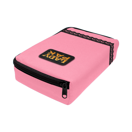 713TP_The_Pak_Dartcase_LadyPak_Rosa_2 Das Bild zeigt ein pinkfarbenes Etui namens "The Pak Dartcase - Lady Pak" mit einem schwarzen Reißverschluss. Auf dem Etui ist ein Patch mit der Aufschrift "LADY PAK" angebracht und es ist mit schwarzer Spitze verziert.